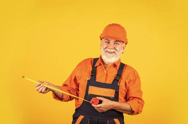 Senior Builder verwenden Band-Line für Maß. Messung. Ingenieur-Größenmessung. Bauarbeiter halten Maßband. Engineering und Reparatur. glücklicher Tischler. Handwerker-Messwand — Stockfoto