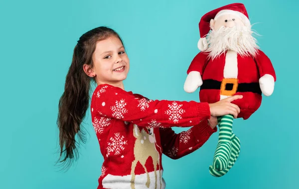 Merry christmas. Christmas vibes concept. Christmas traditions. Dear Santa. Small kid carry Santa toy blue background. Little girl toy present. Winter holidays. Gift brings joy and happiness — Stock Photo, Image