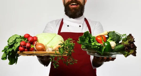 Homme à barbe isolée sur fond blanc. Chef détient des légumes — Photo