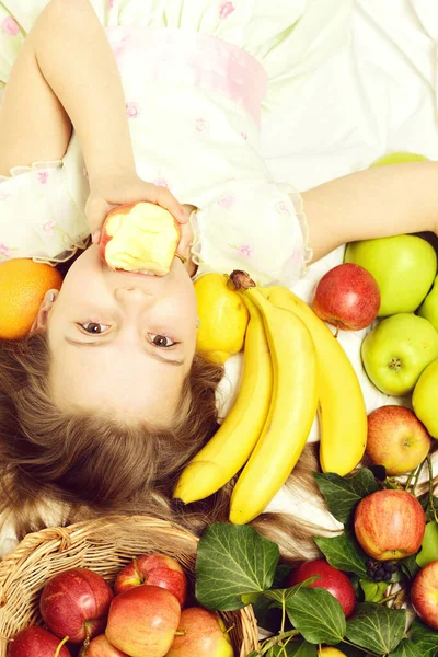 Kleine glückliche Mädchen essen exotische Früchte oder Sommer Hintergrund — Stockfoto