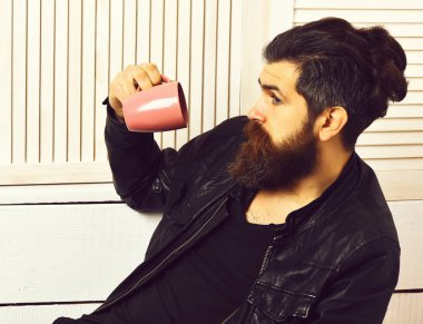 Kafkasyalı vahşi hippi elinde bardak ya da kupa tutuyordu.