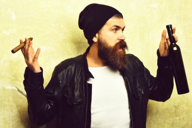 Sakallı, Kafkas hippisi elinde şişe, puro içiyor.