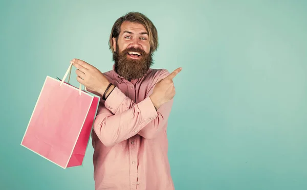 Va faire le paiement au supermarché. meilleure offre de vente. heureux homme barbu avec sac cadeau. joyeux hipster brutal tenir cadeau. sac à provisions en papier. surprise d'anniversaire à la fête. homme avec paquet — Photo