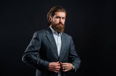 Sakallı adam gri takım elbise giyer. Şirket tarzı, moda stilisti.