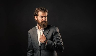 Sakallı adam gri takım elbise giyiyor. Şirket tarzı, başarılı iş adamı konsepti.