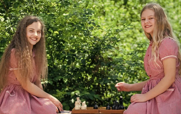 Verseny sikerjáték. Két tini lány sakkozik a parkban. retro gyerekek sakkoznak. stratégiai koncepció. Társasjáték. Tervezési stratégia sakkfigurákkal. Logikai játék az agy fejlődését — Stock Fotó