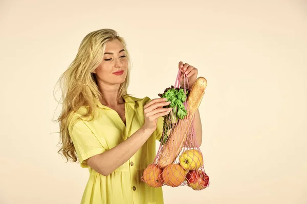Mädchen im Kleid tragen Einkaufstüten. Frau hält Einkaufstasche mit Obst in der Hand. Mehrwegtasche. Lebensmittelgeschäft. Tasche mit Lebensmitteln. Mehrweg-Umhängetasche. Bewusster Konsum. Öko-Trend. Null-Abfall-Konzept — Stockfoto