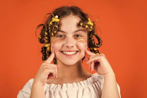 그냥 웃어. 아름다움을 위해 마스크를 쓰는 것이죠. 귀여운 아이가 눈 밑에 패치를 들고 서 있습니다. 어린이 패션 모델 개념입니다. 어린이가 머리 모양을 하고 있다. 곱슬머리의 행복 한 소녀 — 스톡 사진