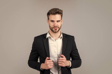 Seni baştan çıkarıyorum. Şık bir emlakçı. Yakışıklı adam resmi takım elbise giyer. Gömlek ve ceket giyen kendine güvenen bir iş adamı. patron erkek. Gri arka planda seksi CEO. Modern ofis hayatı. karizmatik iş sahibi