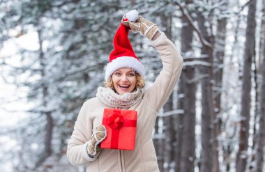 Benim için öyle. Hediye zamanı. Kırmızı Noel Baba şapkalı kadın hediye kutusunu tutuyor. Boks günü. Kış alışverişi. hediye ve sürpriz konsepti. Herkese mutlu noeller dilerim. Yeni yılınız kutlu olsun. xmas tatili