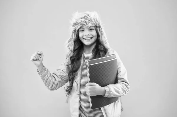 Atrápame en mi mejor momento. colegiala llevar mochila y libros ir a casa. No más exámenes. pequeña chica feliz sombrero de oreja. de vuelta a la escuela. vacaciones de invierno. niño ropa de abrigo fondo rosa. la vida diaria de los alumnos —  Fotos de Stock