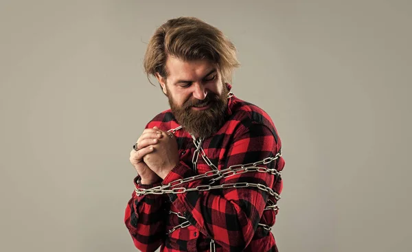 There is always a way out. sense of freedom. caucasian man with powerful metal chain on body. handsome man with beard hold chain. concept of freedom. man chained problems. liberation from slavery