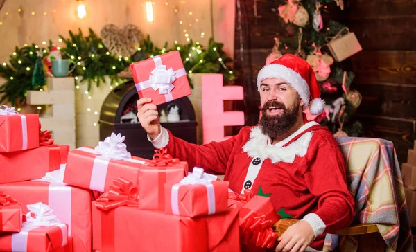 Los regalos de paquetes serán entregados a su destino. Enviando regalos. Saludos desde Santa. Residencia de Santa Claus. Vacaciones de invierno. Ambiente acogedor en casa. Barbudo hombre sentarse en sillón con montón de regalos — Foto de Stock