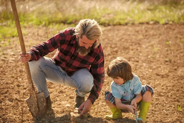 Farming agriculture. Bearded man teach child farming. Hobby farming activity. Farming and gardening. Family farm. Agriculture and homesteading. Growing plants. Horticulture. Spring season