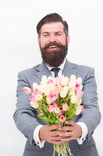 C'est pour toi. Journée des femmes. Le 8 mars. Cadeau de printemps. Homme barbu hipster avec des fleurs. Célébrez le printemps. Je fais une surprise. Messieurs avec des tulipes. Le printemps arrive. Salutations. Homme barbu bouquet de tulipes — Photo