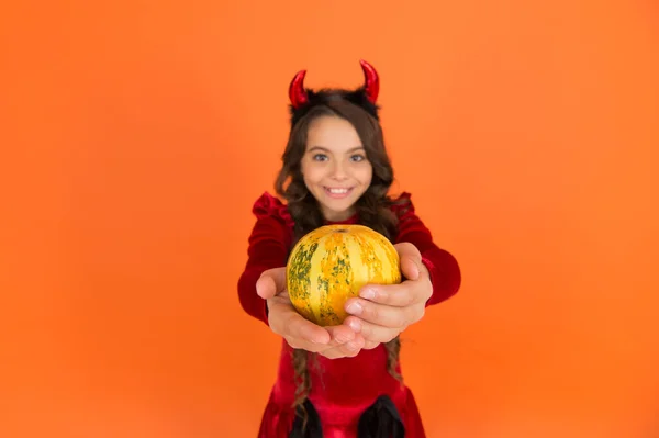 Vegetal de abóbora em mãos de criança diabo feliz usar chifres traje de imp na festa de Halloween, foco seletivo, comida de Halloween — Fotografia de Stock