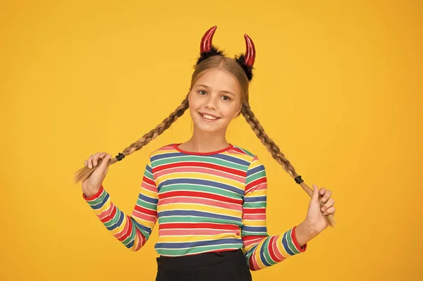 Coafură ușoară de vacanță pentru părul lung. Copilul de Halloween ține părul lung. Fetiţa poartă coarne de diavol roşu cu coarne de păr împletite. Salonul de coafură. Frumusețe și salon de păr — Fotografie, imagine de stoc