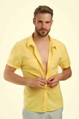 Sıcaklık mevsimi. Modern moda. Soyunma odası. Çekici bir adamın gömleğini çıkarması. Cazibesine güveniyor. Sakallı adam gündelik tarzda. Yakışıklı maço manken. Seksi maço alışveriş kıyafetleri. Sıcak bir gün