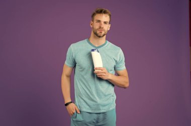 Sıvı sabun. Cildime değer veriyorum. Neşeli yakışıklı sporcu elinde şişe şampuan duş jeli tutuyor. Erkekler için şampuan kremi. Şampuanlı plastik bir kap. Saç tipi için şampuan. Saçlarını güçlendir.