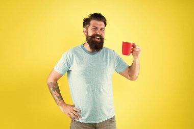 Kahve dükkanı. Sakallı adam sabah kahvesini içer. Çay zamanı. Sütlü cappuccino. Gerçek özel kahve büyük bir iş haline geliyor. Enerji konsepti. Hipster barista sarı arka plan