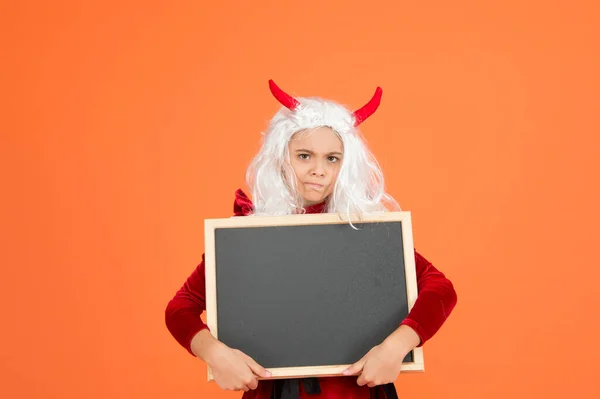 Bambino infelice indossare corna diavolo e parrucca capelli bianchi tenendo lavagna scuola per la pubblicità di Halloween, felice Halloween — Foto Stock