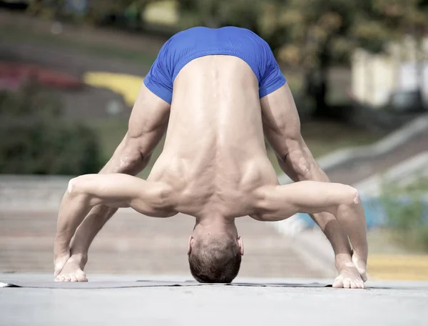 Hombre atlético haciendo asanas de yoga en el parque — Foto de Stock