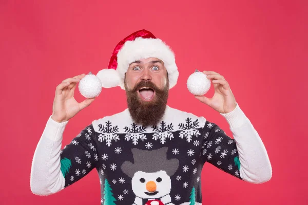 Homem de camisola segurar bolas de neve decorativas. Tempo de compras de Natal. decoração de árvore. homem barbudo surpreso em Papai Noel. feliz ano novo festa divertida. celebrar as férias de inverno. Feliz Natal. Feliz Natal. É para ti. — Fotografia de Stock