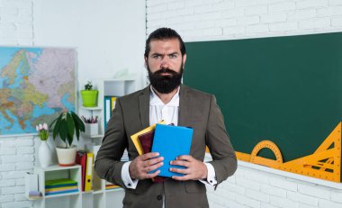 Öğrenme adası. Sınavı geç. Konuyu öğrenmek. Sakal tutan ciddi bir adam. Eğitim için edebiyat. gayri resmi eğitim. Ders sırasında erkek öğrenci sınıfta.