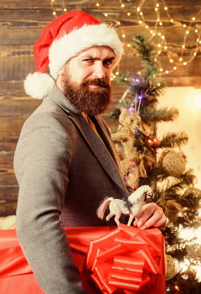 Doručovací vánoční dárek. Doručovací služba. Vánoční dárek. Muž v Santově klobouku má dar. Vánoční duch je tady. Rozšiřte štěstí a radost. Vousatý chlap nosit Santa Claus klobouk nosit vánoční dárek box — Stock fotografie
