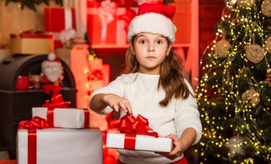 Sihir zamanı. Xmas hediye alışverişi. Aile geleneği. Hediye paketi. Mutlu Noeller ve mutlu Noeller. Kış tatili Küçük kız hediye kutusunu tutuyor. Çocuk mevcut kutucuğu dekore edilmiş iç arkaplan