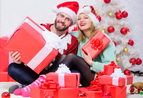 爱情是最好的礼物。恋爱中的夫妻享受圣诞节庆祝活动。女人和留胡子的男人都戴着圣诞老人背景的圣爪帽。平安夜与亲爱的。家里的已婚夫妇 — 图库照片