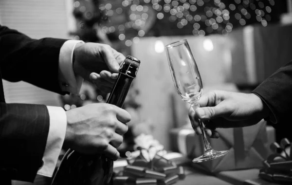 Beba champanhe ou vinho espumante. Celebre o Ano Novo com o champanhe. Último minuto antes do ano novo. Contagem regressiva de ano novo. Mãos abrindo garrafa de champanhe e segure vidro decorações de Natal fundo — Fotografia de Stock