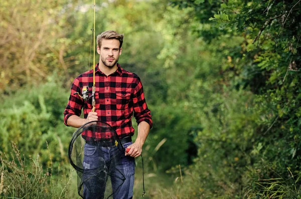 Hipsterski wędkarz z siatką spinningową. Mam nadzieję na dobre łowienie. Dzień wędkowania. Przystojny facet w szarej koszuli ze sprzętem wędkarskim. Łowienie ryb w moim hobby. Koncepcja weekendu letniego — Zdjęcie stockowe