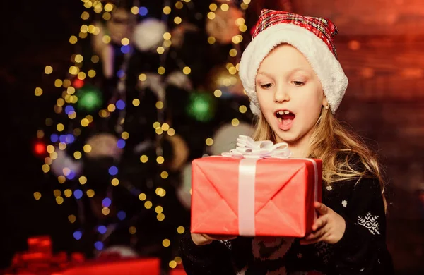 Найкращий сюрпризний подарунок. Чарівна дитина дивиться на подарункову коробку з несподіванкою. Маленька дівчинка тримає рот відкритим з великим сюрпризом в день боксу. Здивована маленька дитина тримає подарунок Різдво. Сюрприз для неї — стокове фото