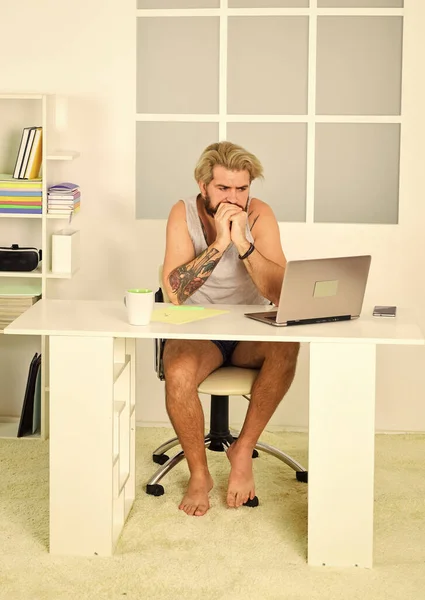 Blocco auto isolamento e quarantena. Un tipo scalzo che lavora da casa. Comodo posto di lavoro. I social network. Distanze sociali. Ho sempre voluto lavorare da casa. Un uomo lavora con un portatile. Troppo pigro per lavorare — Foto Stock