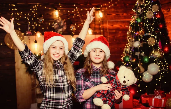 Pronto para as férias. Irmãzinhas de chapéus vermelhos. Somos uma família. Filhos de elfos. Pai Natal. Irmãzinhas do Pai Natal. Tempo de Natal. Férias em família. Irmãs felizes. Feliz Ano Novo. Festa familiar — Fotografia de Stock