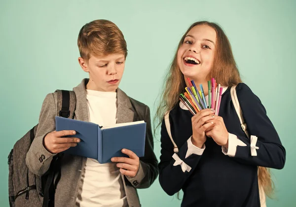 Wir schreiben unsere Zukunft. Glückliche Jungen und Mädchen halten Stifte und Lesebuch in der Hand. Kleine Kinder lernen Lesen und Schreiben in der Schule. Schreibenlernen in der Grundschule. Verbesserung der kalligraphischen Schrift — Stockfoto