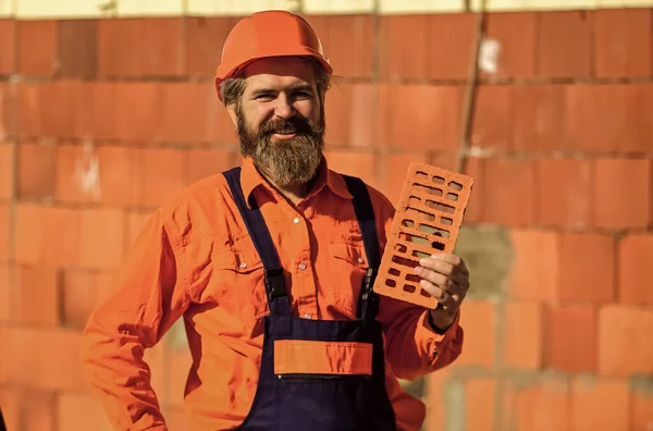 Element in masonry construction. Builder hold brick. Bearded man wear hard hat at construction site. Brick building material used to make walls. Lightweight brick made from expanded clay aggregate — Stock Image Element in masonry construction. Builder hold brick. Bearded man wear hard hat at construction site. Brick building material used to make walls. Lightweight brick made from expanded clay aggregate Stock Photo