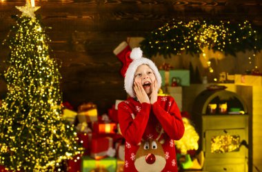 İyi tatiller. Noel zamanı kompozisyonu. Mutlu yıllar. Sürpriz çocuk Noel hediyelerini bekliyor. Hediye alma zamanı. Alışveriş satışları. Tatil hazırlığı ve kutlama. Küçük çocuk Noel Baba şapkası takıyor.