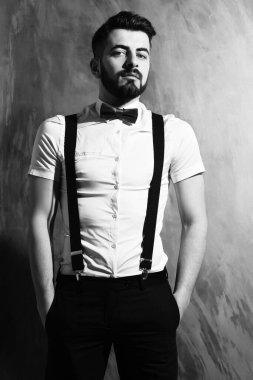 Stüdyo duvarında ciddi bir yüzü olan sakallı bir adam.