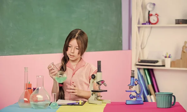 Experimento científico. Niña pequeña con frasco de laboratorio. de vuelta a la escuela. educación en biología. Laboratorio escolar. Tecnología moderna. lección de ciencia con microscopio. chica estudiar química con tubo de ensayo —  Fotos de Stock