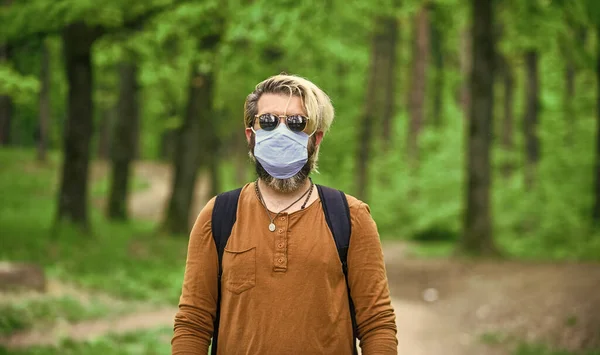 Man met het gezichtsmasker als gevolg van luchtvervuiling. bescherming van de mens tegen luchtverontreiniging of het coronavirus covid-19 door het dragen van een masker. infectie te voorkomen. mannetje genieten van de natuur wandelen — Stockfoto