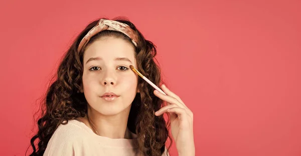 Klein meisje met lang krullend haar. Feest met cosmetica. Ontspan en vermaak je. Een klein meisje in een schoonheidssalon. klein meisje in retro mode hoofddoek. Make-up voor kind. Gelukkige kinderdag. kopieerruimte — Stockfoto