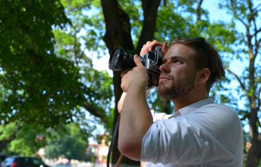 Fotoğrafçı büyük mercekli retro kamera tutuyor.