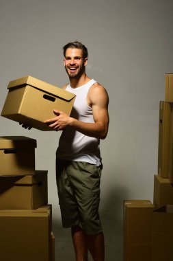 Gülen yüzlü maço beyaz tişört ve şort giyiyor.