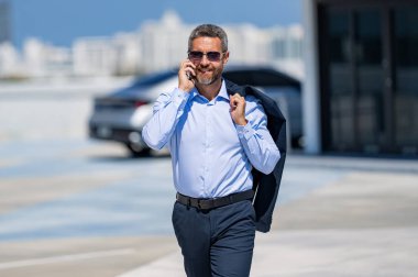 Man phone conversation. Mature Hispanic businessman with phone. Business communication. Negotiation online. Businessman talking on phone outdoor. Businessman reply on business call.