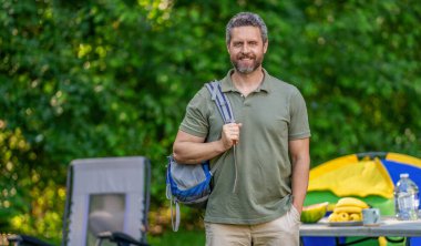 Hispanic man in forest. Hiker with backpack hiking in forest. Male hiker walking in forest. Man traveler hike with backpack. Hiker adventure. Trekking lifestyle. Man hiking in countryside, copy space.