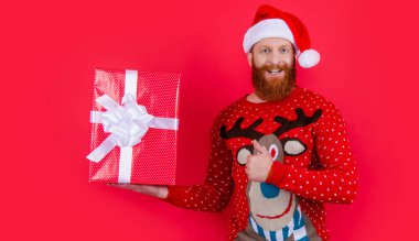 smiling man with christmas present. merry christmas. santa man hold christmas present isolated on red.