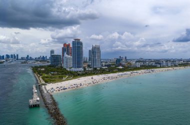 Miami sahil şeridinin hava gece görüşü. Miami Okyanusu 'nun üzerindeki alacakaranlık silueti. Miami Sahili kıyısı gün batımından sonra parlıyor