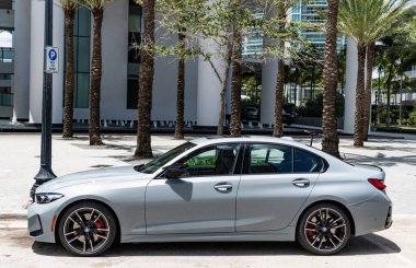 Miami, Florida, ABD - 19 Nisan 2025: BMW M340i 2023 spor araba sedanı. Lüks sedan spor araba M3 yarışması. Araba M3 yarışması XDrive dışarıda park halinde. Limon rengi sedan araba, yan görüş.